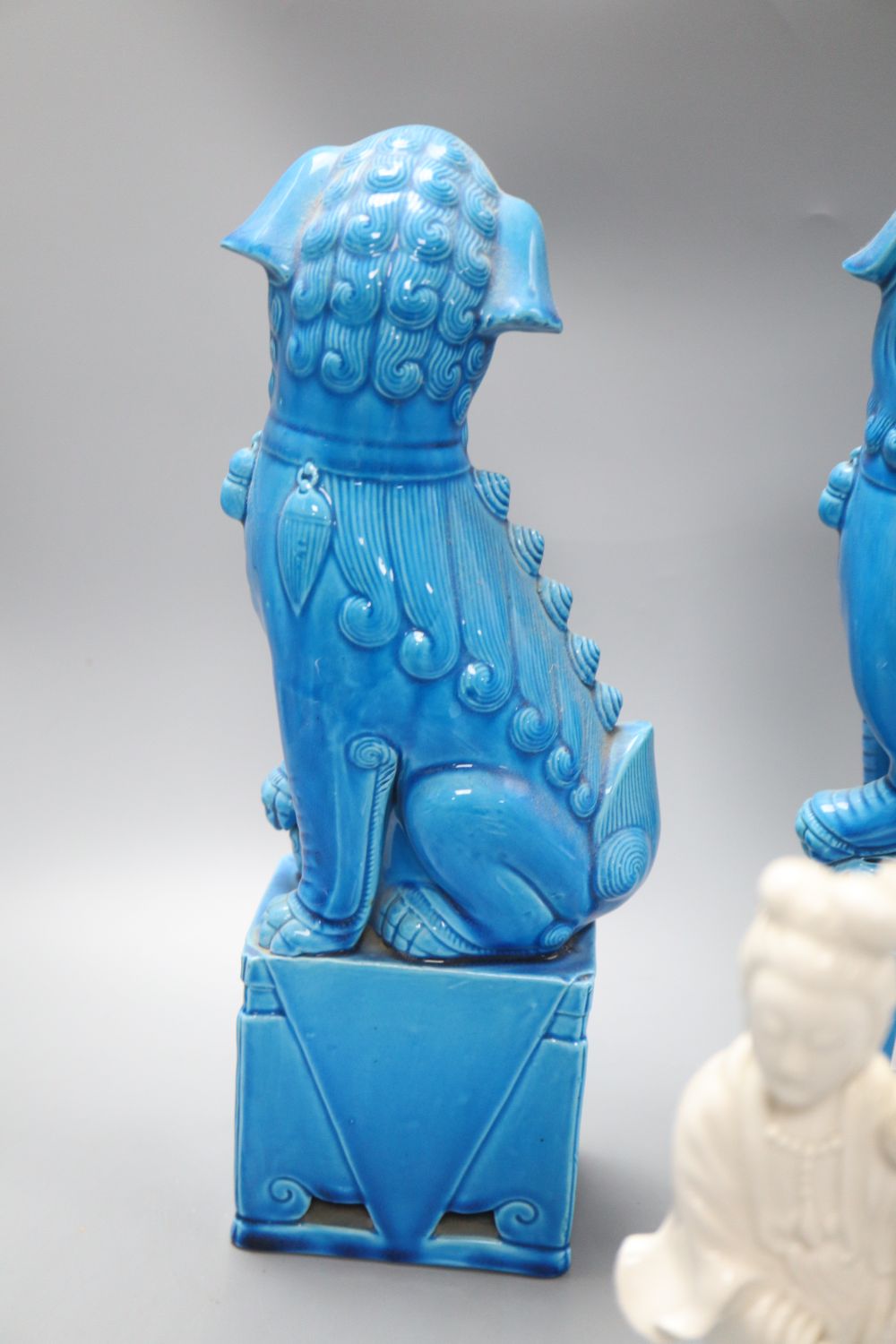 A pair of Chinese turquoise glazed temple dogs, height 36cm and a blanc de chine Kwan Yin